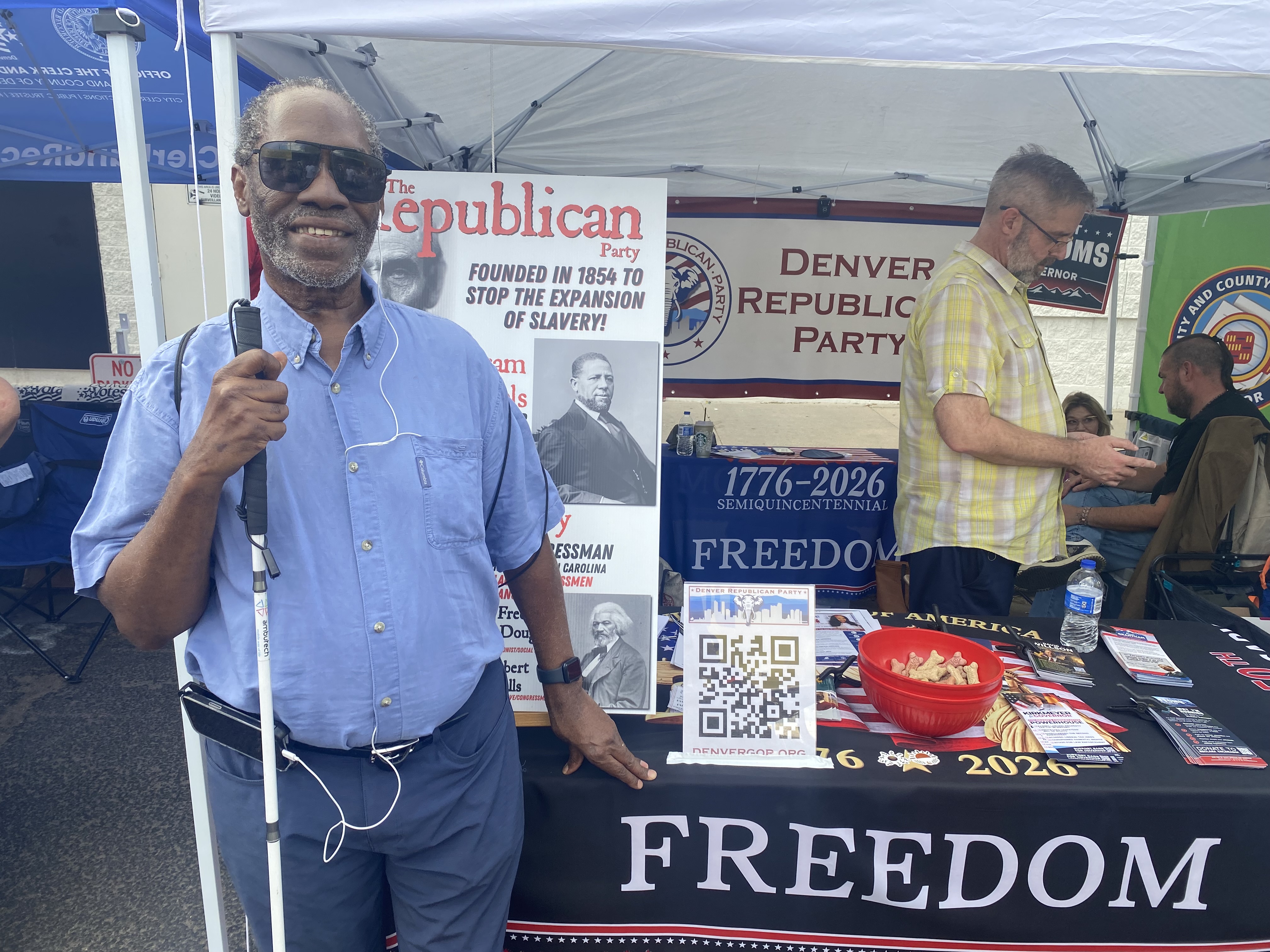 photo of Johnnie standing in front of his booth at outdoor event